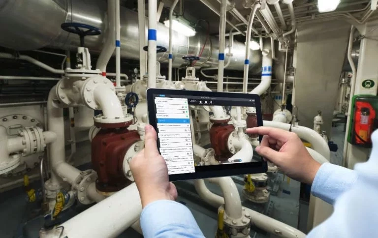 Man with a tablet performing a video assistance inspection of offshore vessels
