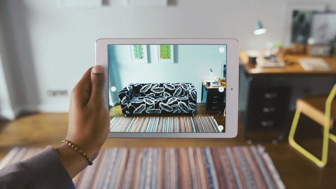 Consommateur utilisant la r&eacute;alit&eacute; augment&eacute;e d&rsquo;Ikea pour visualiser des meubles dans son salon